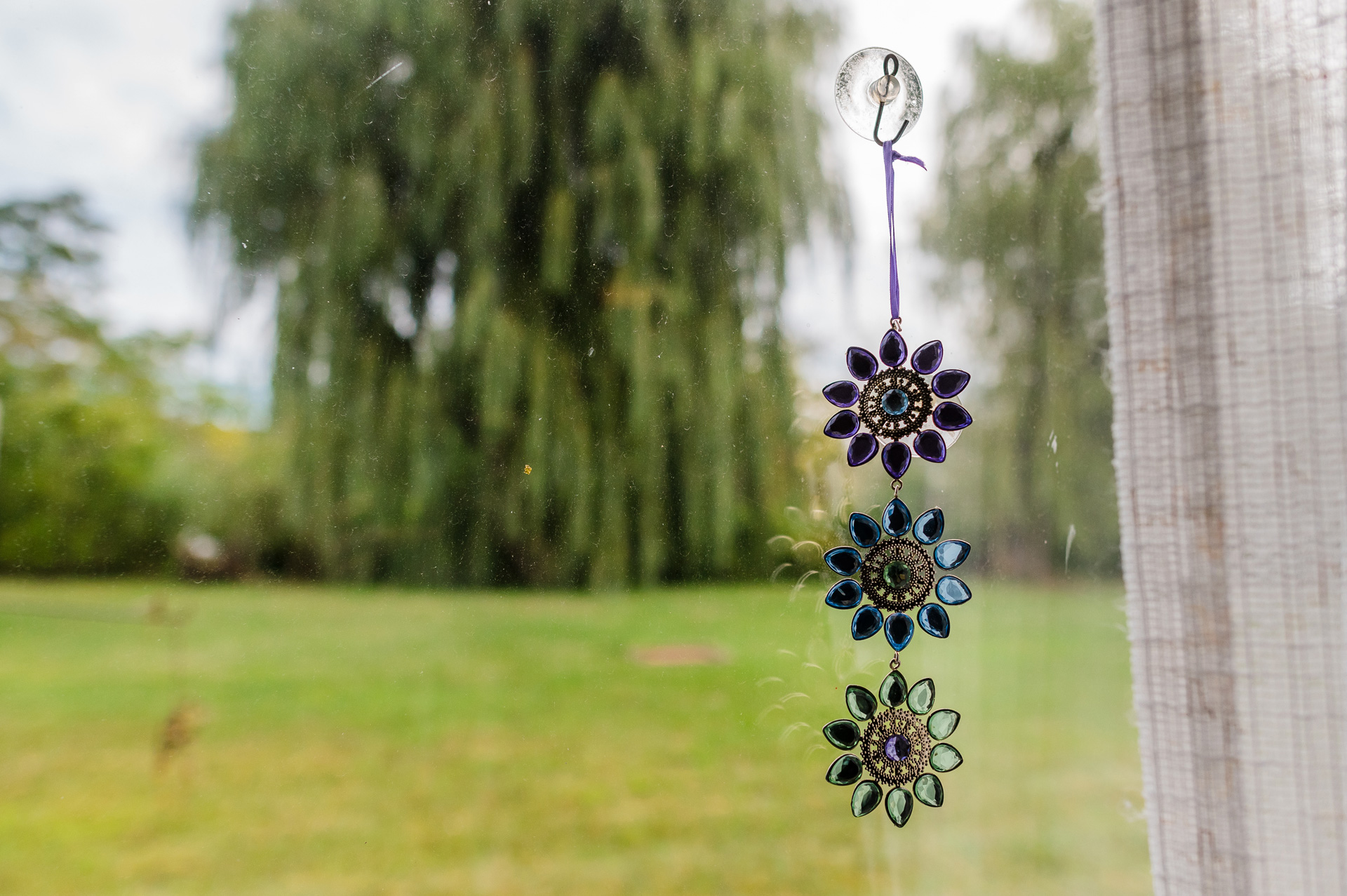 glass suncatcher in a window overlooking a lawn